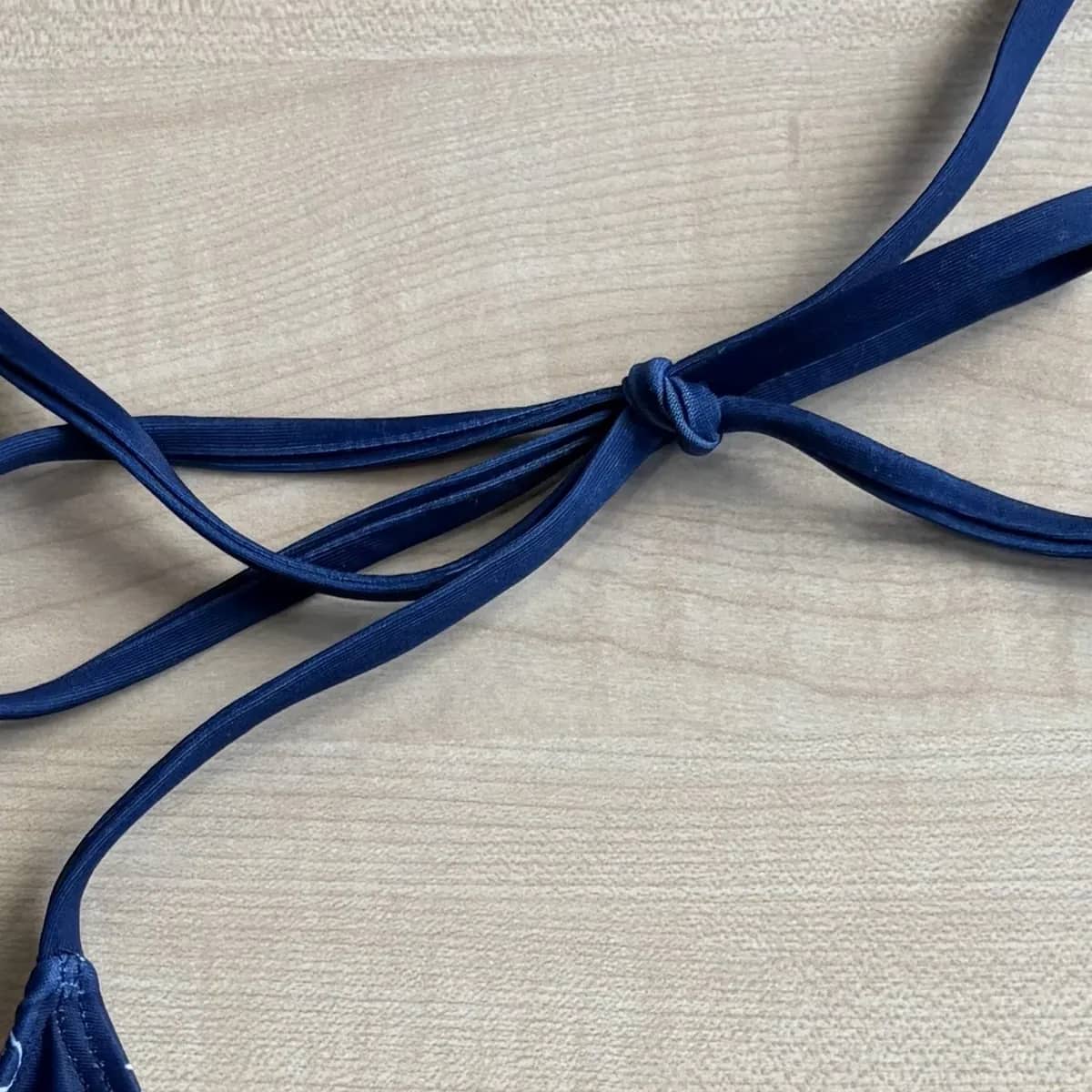 The halter tie knotted at the neck